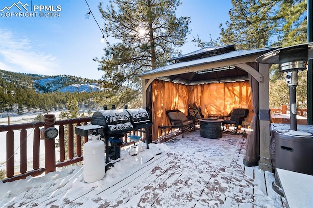 snow covered deck with a fire pit and a gazebo