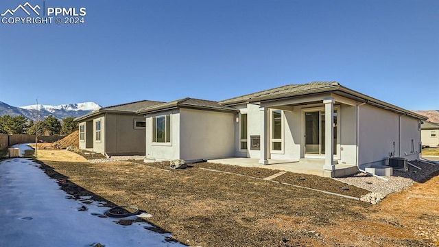 back of house with a mountain view and central AC unit