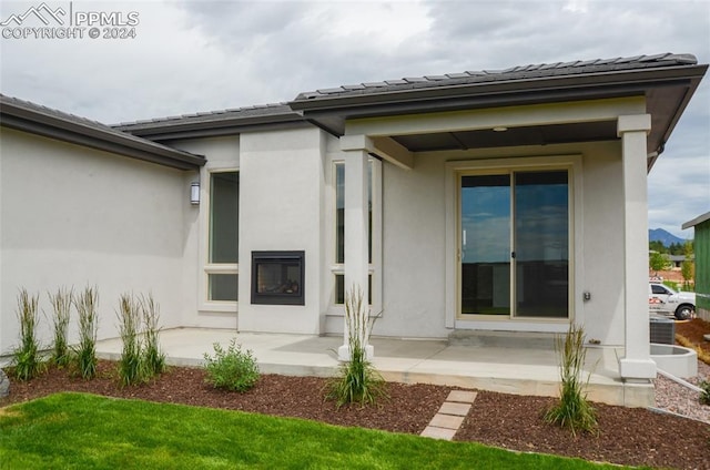 rear view of house with stucco siding and a patio area