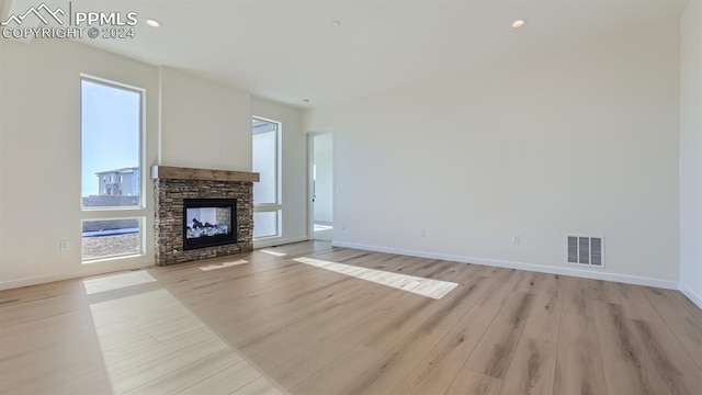 unfurnished living room featuring light hardwood / wood-style flooring and a fireplace