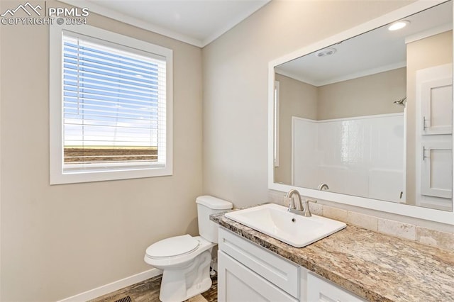 bathroom featuring toilet, a healthy amount of sunlight, hardwood / wood-style flooring, and vanity with extensive cabinet space