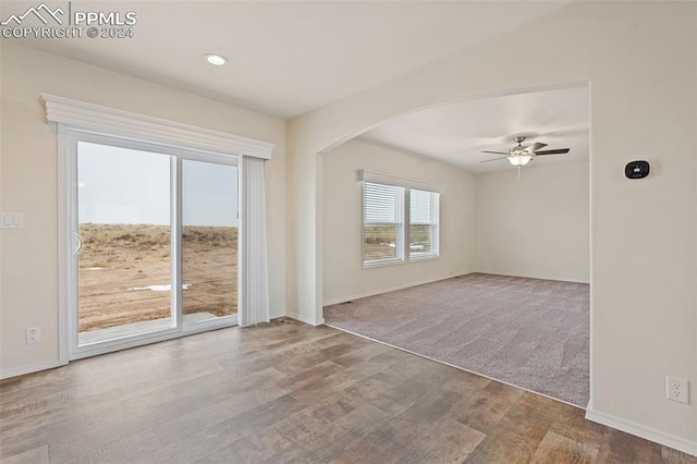 spare room featuring ceiling fan and dark carpet