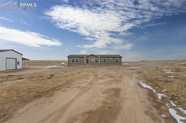 view of front of home with a rural view, an outdoor structure, and a garage