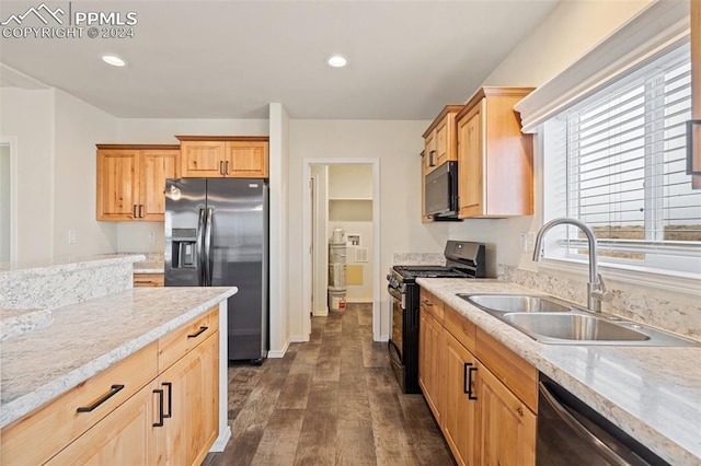 kitchen featuring stainless steel appliances, sink, dark hardwood / wood-style flooring, and light stone countertops