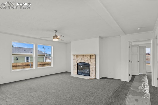 unfurnished living room featuring ornamental molding, a fireplace, ceiling fan, and dark carpet