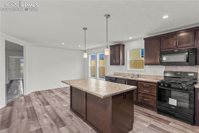 kitchen featuring pendant lighting, a center island, light hardwood / wood-style flooring, black appliances, and dark brown cabinetry