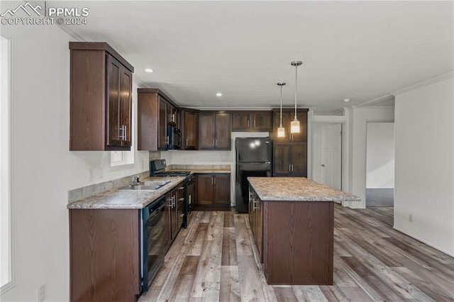 kitchen with a kitchen island, light hardwood / wood-style flooring, black appliances, decorative light fixtures, and dark brown cabinetry