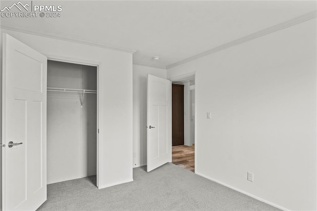 unfurnished bedroom featuring a closet, ornamental molding, and light carpet