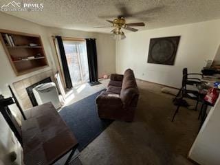 carpeted living room with a textured ceiling, ceiling fan, and built in shelves