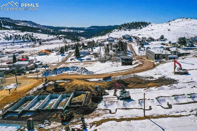 snowy aerial view featuring a mountain view