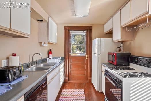 kitchen with white cabinetry, dark hardwood / wood-style floors, gas range, dishwasher, and sink