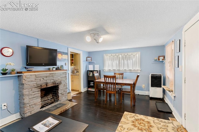 living room featuring dark hardwood / wood-style flooring, a textured ceiling, and a fireplace