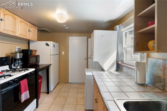 kitchen with light brown cabinets, tile counters, white appliances, and light tile flooring