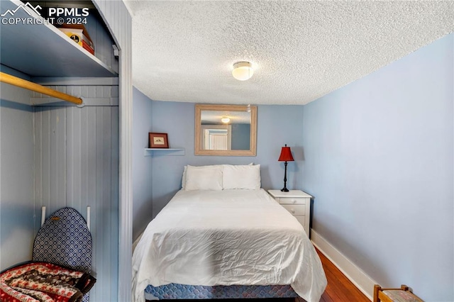 bedroom with a textured ceiling and hardwood / wood-style flooring