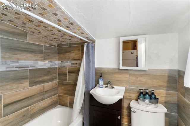 full bathroom featuring tile walls, backsplash, toilet, vanity, and shower / bath combo