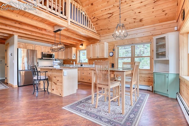 kitchen with decorative light fixtures, a kitchen island, stainless steel appliances, and a breakfast bar