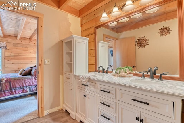 bathroom featuring wooden ceiling, wood walls, beam ceiling, and double vanity