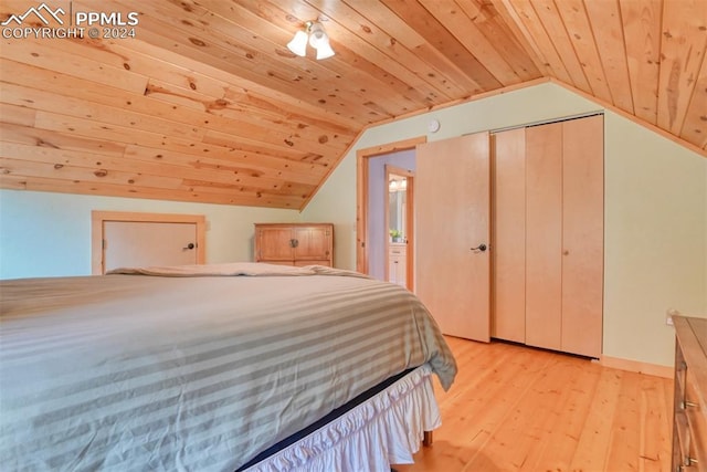 unfurnished bedroom with a closet, ensuite bath, light hardwood / wood-style flooring, lofted ceiling, and wooden ceiling