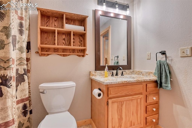 bathroom featuring toilet and vanity