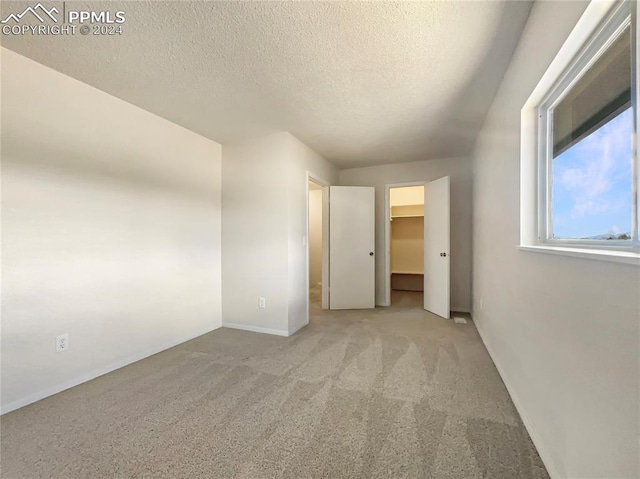 carpeted empty room with a textured ceiling