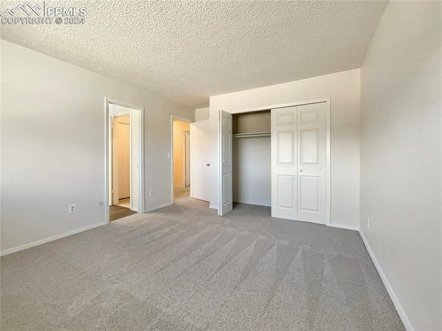 unfurnished bedroom with carpet floors, a closet, and a textured ceiling