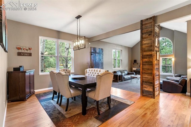 dining room featuring lofted ceiling, light hardwood / wood-style flooring, and an inviting chandelier