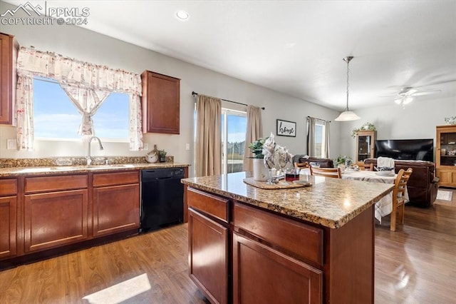 kitchen with a kitchen island, wood-type flooring, black dishwasher, sink, and hanging light fixtures