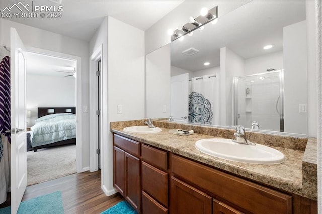 bathroom featuring vanity, a shower with shower door, and wood-type flooring