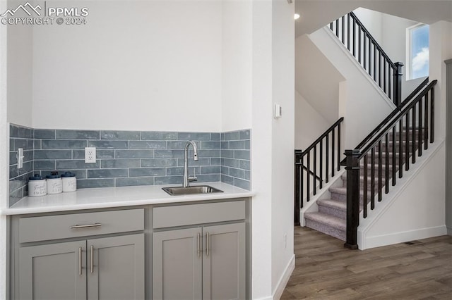 interior space featuring backsplash, sink, and hardwood / wood-style floors