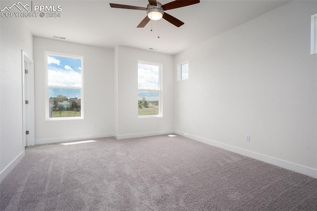 carpeted spare room with ceiling fan