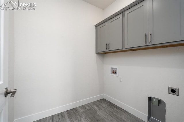 laundry area with cabinets, washer hookup, electric dryer hookup, and wood-type flooring