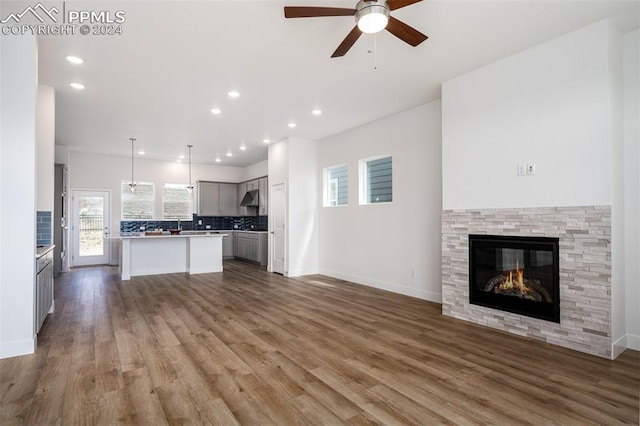 kitchen with gray cabinetry, ceiling fan, a center island, and backsplash