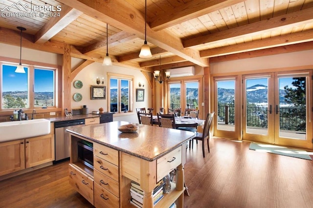 kitchen featuring pendant lighting, stainless steel dishwasher, beam ceiling, a mountain view, and dark hardwood / wood-style floors