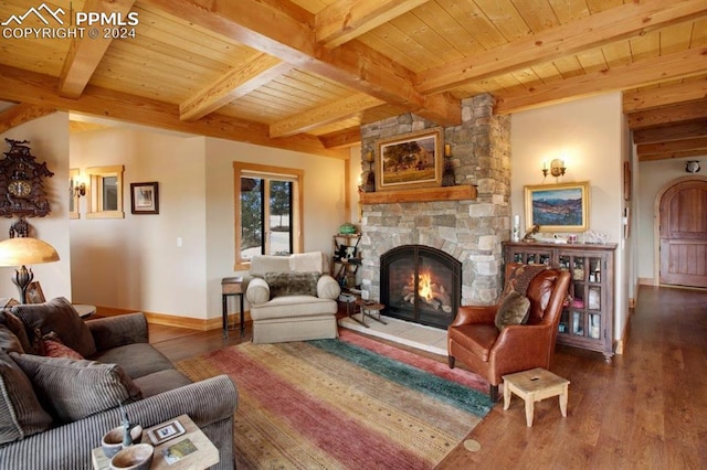 living room featuring a stone fireplace, dark wood-type flooring, beamed ceiling, and wooden ceiling