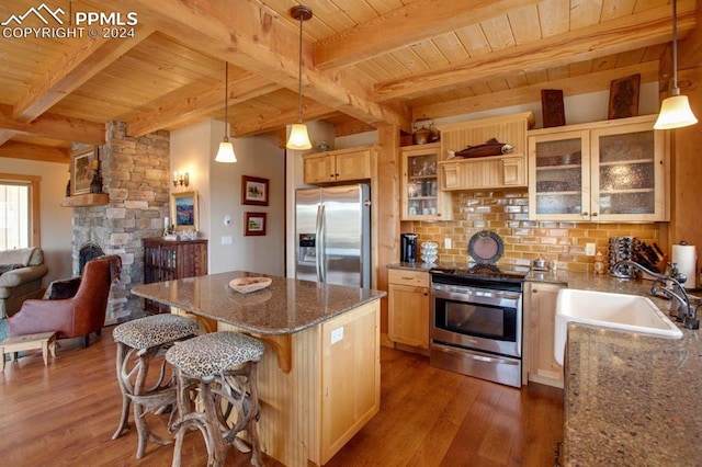 kitchen featuring dark hardwood / wood-style floors, a kitchen bar, a center island, and stainless steel appliances