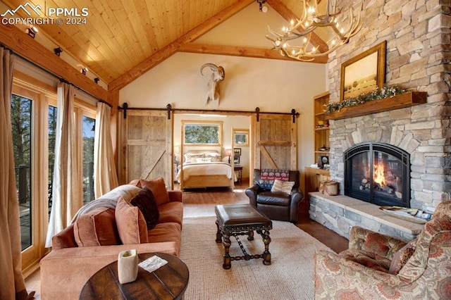 living room with an inviting chandelier, wood-type flooring, a fireplace, a barn door, and beam ceiling