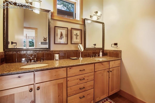 bathroom with vanity with extensive cabinet space, double sink, and a wealth of natural light