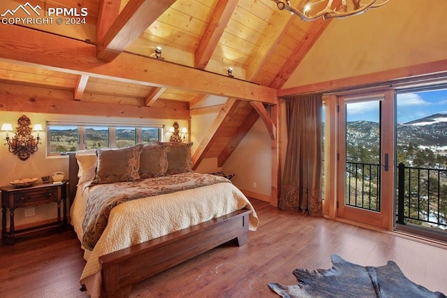 bedroom with a mountain view, hardwood / wood-style floors, access to outside, lofted ceiling with beams, and a notable chandelier