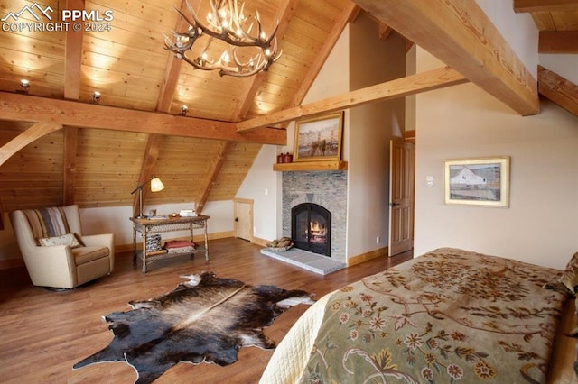 bedroom featuring dark wood-type flooring, a tiled fireplace, wood ceiling, and a chandelier