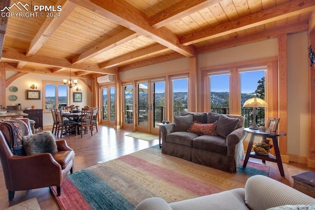 living room with light wood-type flooring, beamed ceiling, a chandelier, and a healthy amount of sunlight