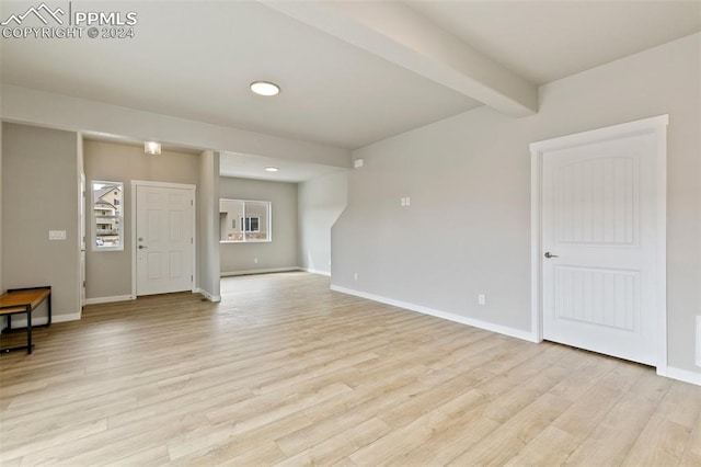 living room featuring beam ceiling and light hardwood / wood-style floors