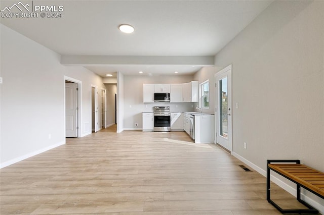 kitchen with white cabinetry, sink, light hardwood / wood-style floors, and appliances with stainless steel finishes