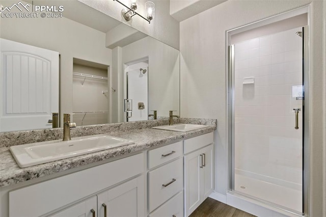 bathroom with vanity, hardwood / wood-style flooring, and a shower with shower door