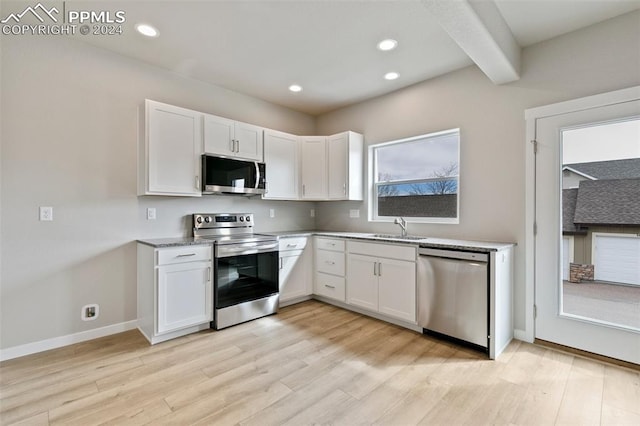 kitchen with appliances with stainless steel finishes, white cabinetry, and sink