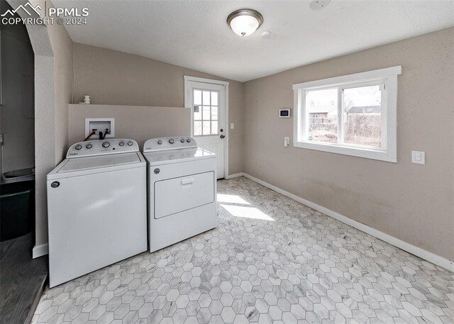 laundry area with washer hookup, separate washer and dryer, and light tile flooring