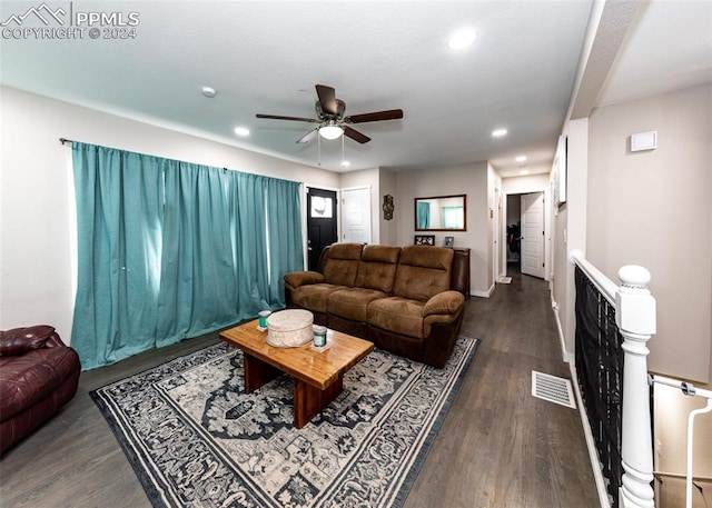 living room featuring ceiling fan and dark hardwood / wood-style flooring