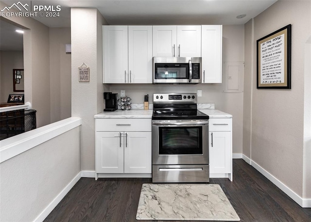 kitchen featuring stainless steel appliances, white cabinetry, dark hardwood / wood-style flooring, and light stone counters