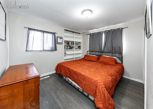 bedroom with dark hardwood / wood-style floors