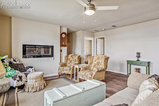 living room featuring ceiling fan and dark wood-type flooring