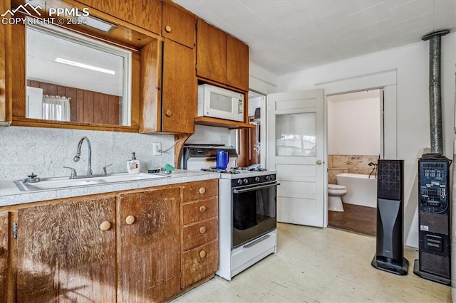 kitchen with white appliances, backsplash, and sink